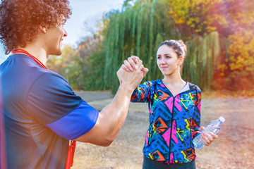 Exercise - sporty couple giving high five to each other after workout.