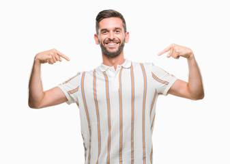 Young handsome man over isolated background looking confident with smile on face, pointing oneself with fingers proud and happy.