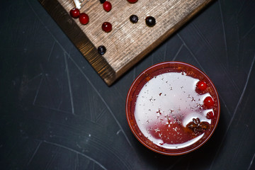 Bar menu hot fruit tea with orange slices, cinnamon and berries on a stone board, copy text background.