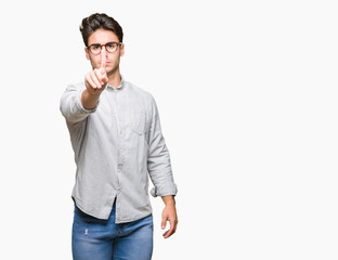 Young handsome man wearing glasses over isolated background Pointing with finger up and angry expression