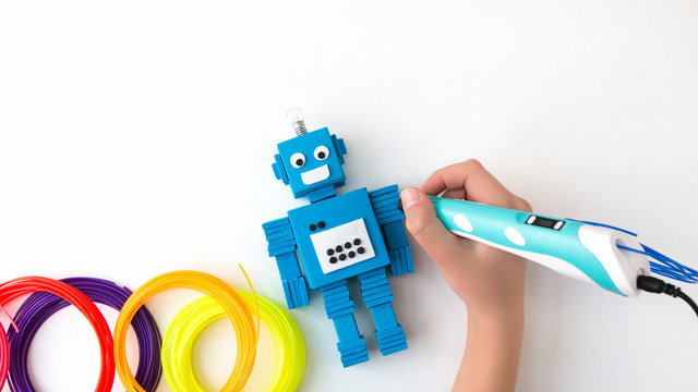 A child, teen boy makes a plastic robot, draws its parts with a 3D pen. STEM and STEAM education. Development, modeling, design and programming of the robot. Modern technologies. DIY.