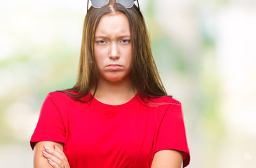 Young beautiful caucasian woman wearing sunglasses over isolated background skeptic and nervous,...