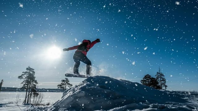 Cinemagraph. Novice snowboarder in a jump with a light snow springboard, winter landscape, video loop