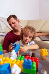 Family love concept. – cute boy playing with toys and his father at home.