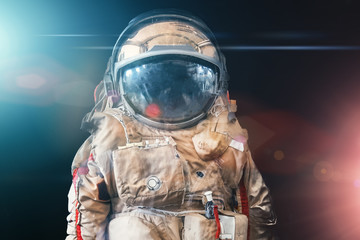 Astronaut or spaceman or cosmonaut on dark space background with blue and red light as sci-fi or fantastic explore background © DedMityay