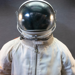 White astronaut or spaceman suit and helmet on grey background © DedMityay