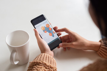 Close-up of businesswoman viewing chart on smartphone. Unrecognizable lady sitting at table with mug and using gadget. Technology concept