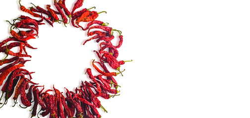 Wreath of dried chili pepper on a white background. Place for text. Wrinkled texture after drying red chili pepper