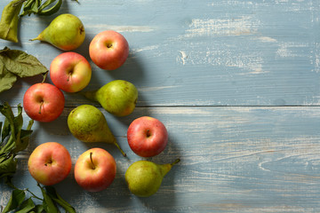 pile of apples and pears on light blue wooden table