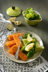 fish sticks with broccoli and lemon garnish