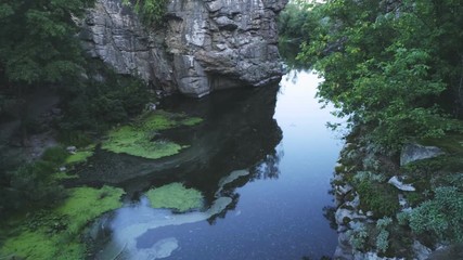 Mountain pool at lofty split rocks with wetland in the Carpathians in summer