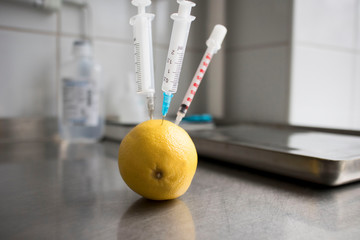 Getting your dose of vitamins from fruits, food and supplements, syringes stuck in lemon