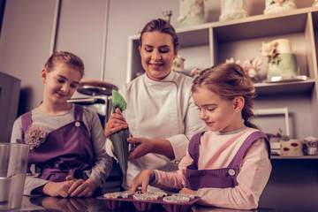 Joyful curious girl observing the process of cooking