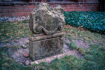 Damaged medieval gravestone at castle's graveyard. Concept of life is short