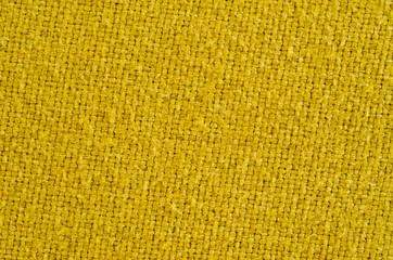Texture of thick, strong mustard color fabric shot close-up.
