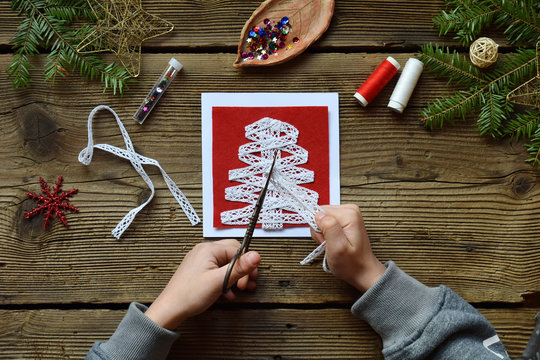 Making Of Handmade Christmas Greeting Card From Felt With Your Own Hands. Children's DIY Concept. Making Xmas Decoration. Step 1. Cut The Openwork Ribbon