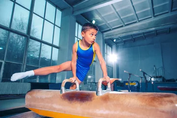 Foto op Plexiglas The sportsman performing difficult gymnastic exercise at gym. The sport, exercise, gymnast, health, training, athlete concept. Caucasian fit little boy © master1305