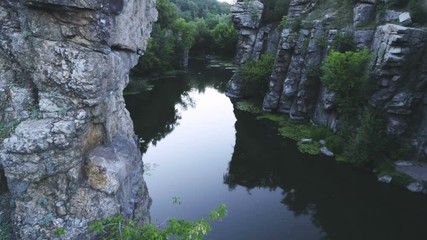 Mountain pond encircled with high rocks in the Carpathian Mountains in summer