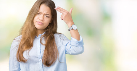 Young beautiful brunette business woman over isolated background Shooting and killing oneself pointing hand and fingers to head, suicide gesture.