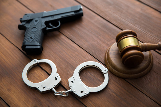 Handcuffs and a judge with gun