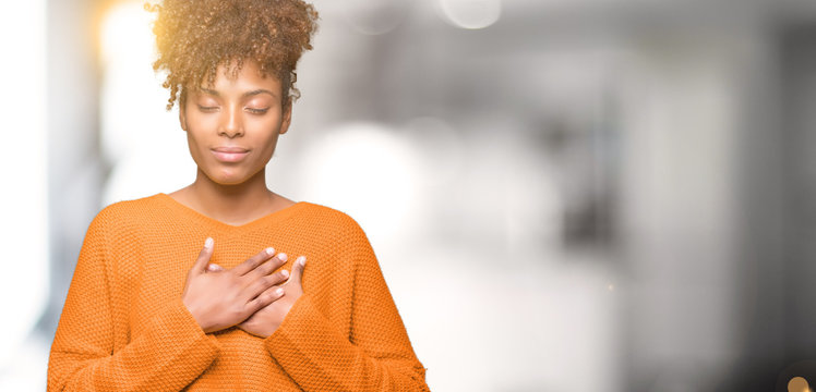 Beautiful Young African American Woman Over Isolated Background Smiling With Hands On Chest With Closed Eyes And Grateful Gesture On Face. Health Concept.