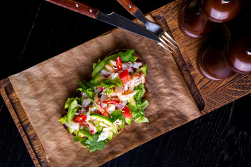 delicious bruschetta with crab meat in restaurant background. Healthy exclusive food served on a wooden board and craft paper