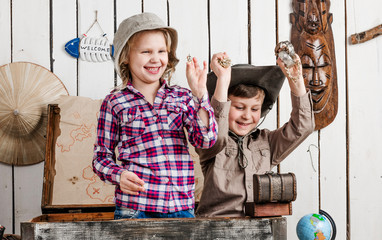 joyful little children with treasures in hands sitting in old chest