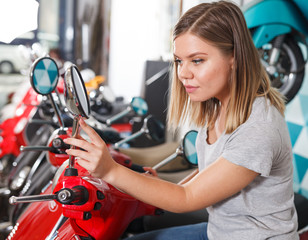 Fototapeta na wymiar Young female is choosing modern motobikes