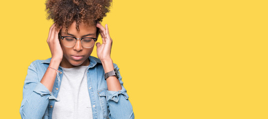 Beautiful young african american woman wearing glasses over isolated background with hand on head for pain in head because stress. Suffering migraine.