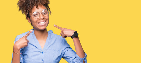 Beautiful young african american business woman over isolated background smiling confident showing and pointing with fingers teeth and mouth. Health concept.