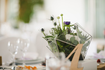 Wooden number four stands on the dinner table served for a wedding dinner