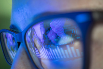 businesswoman in glasses, the reflection in the glasses graphs, tables, sale