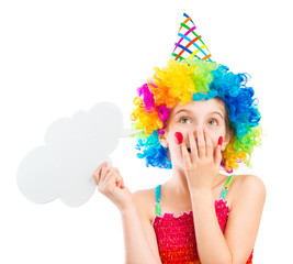 Lively little girl in bright colouful clown wig holding white speech bubble isolated on white background