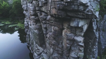 Mountain lake and huge split rocky column in the Carpathian Mountains in summer