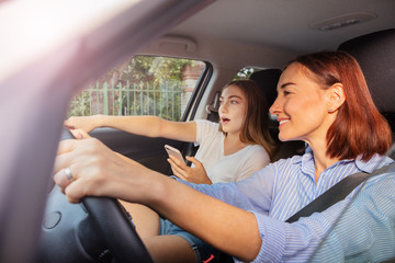 Girl pointing the way to mother during road trip