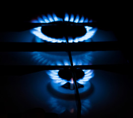 Gas burner with burning blue flame in the dark room