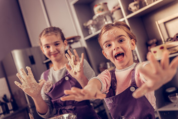Joyful active girl playing with the dough