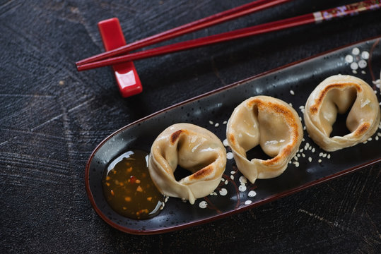 Black Plate With Fried Asian Dumplings, High Angle View On A Dark Brown Stone Surface, Close-up