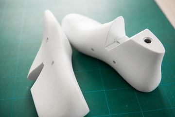 Two white plastic last shoe on rubber secondary cut cutting mat, The equipment used for shoe design.
