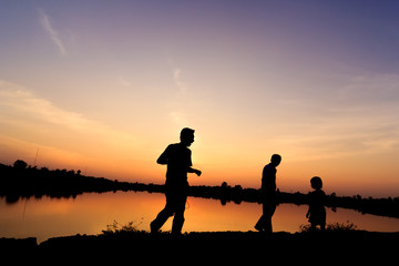 Fototapeta na wymiar the group of people on a lake.Silhouettes of party on a akeat sunset.
