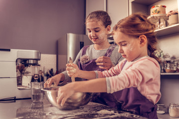 Positive cute girls cooking in the kitchen