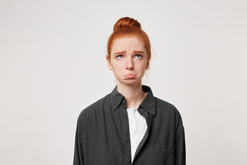 A young red-haired girl looks up with sadness, did not find her name on the list, was late for the...