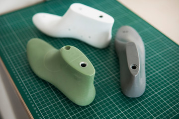 Three plastic last shoe on rubber secondary cut cutting mat, The equipment used for shoe design.