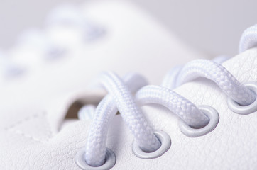 White leather sneakers shoes laces macro blur background