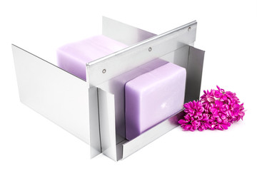 Stainless steel soap cutting tool with handmade soap loaf inside on the white background