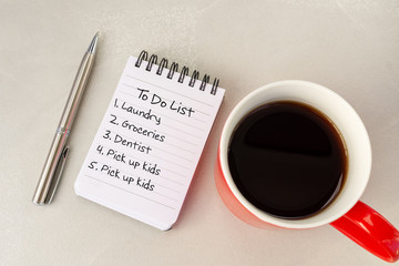 To Do List  text on note pad cup of coffee and pen.