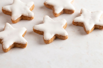 Fototapeta na wymiar Batch of Star Shaped Gingerbread Cookies with White Icing