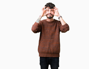 Young handsome man wearing winter sweater over isolated background Trying to open eyes with fingers, sleepy and tired for morning fatigue