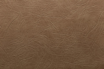 Dark beige faux leather with crumpled embossing. Texture for background and design.