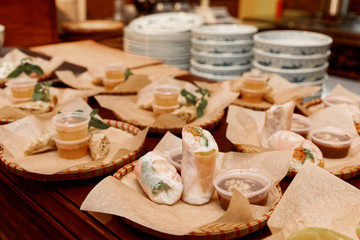 Spring rolls and another food on kitchen counter, toned
